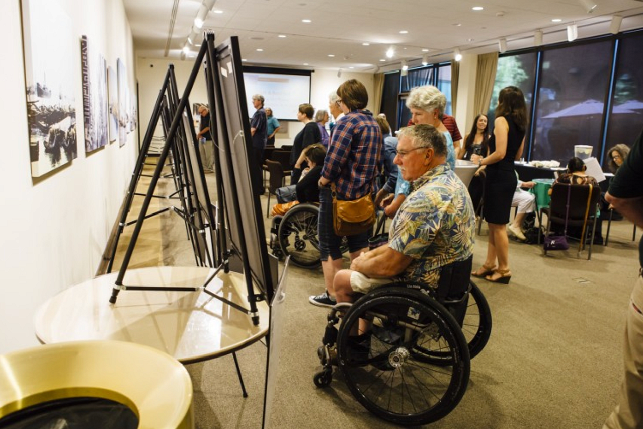 Man in wheelchair looking at poster boards.