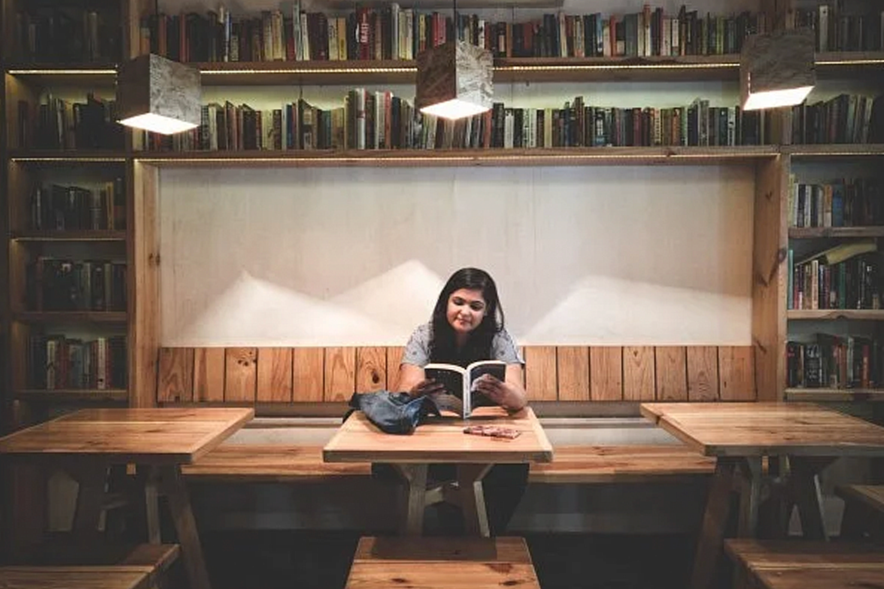 Women reading at a booth surrounded by books.