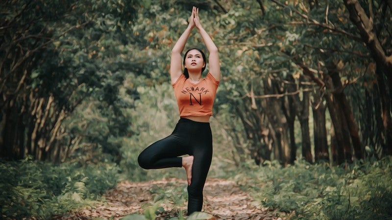 woman doing yoga in the woods