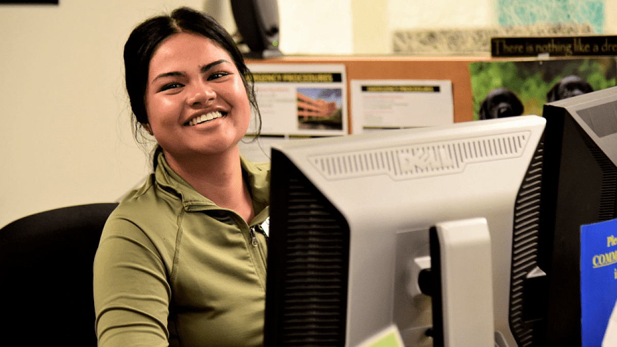 Smiling student sitting at a computer
