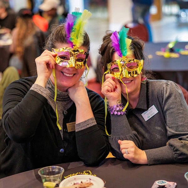 Women wearing Mardi gras mask and smiling