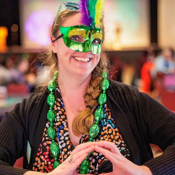 Women wearing Mardi gras mask and smiling