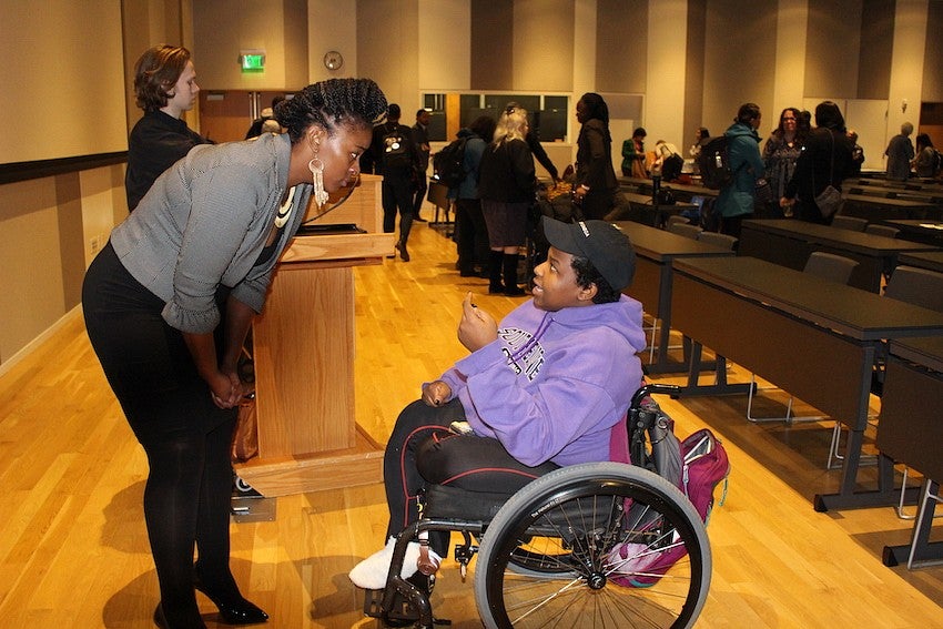 Alisha Moreland-Capuia speaking with student