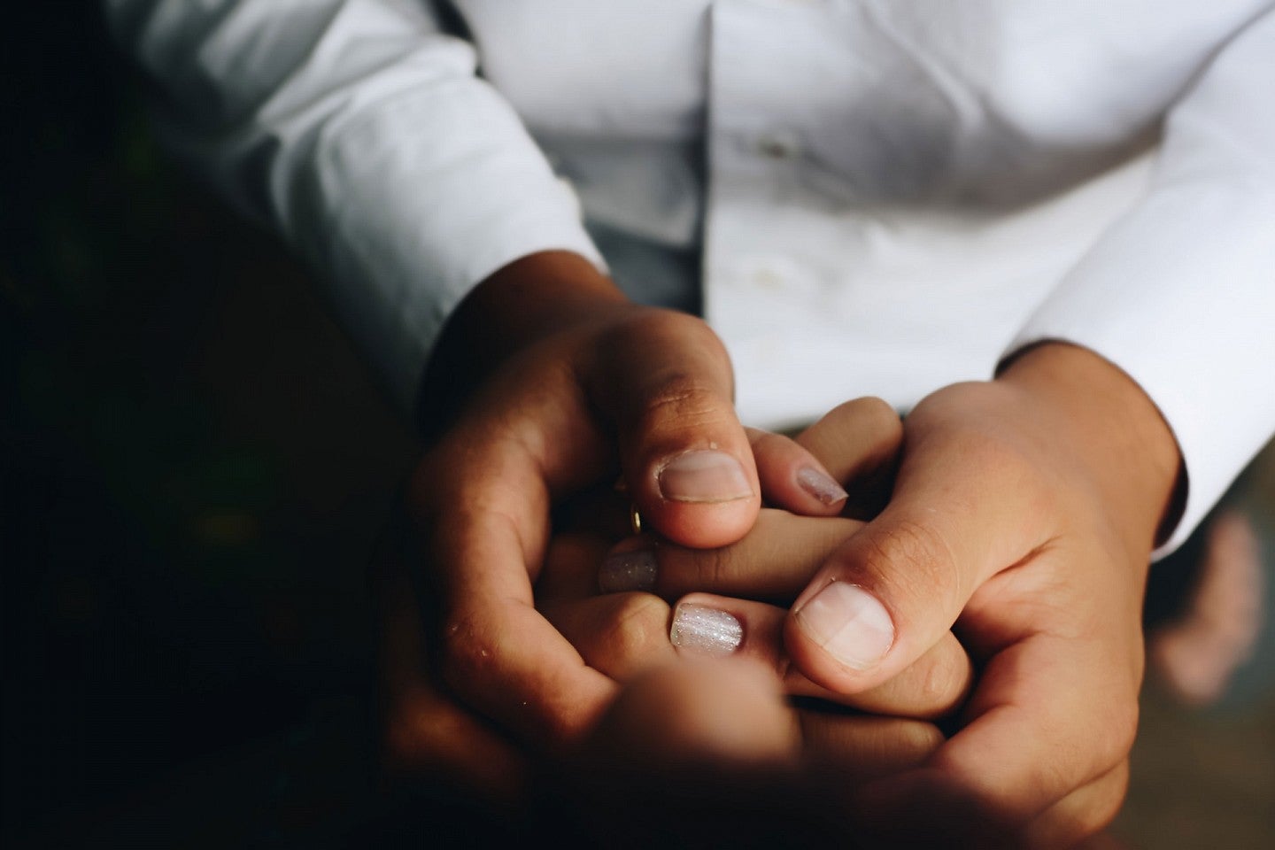 Ethics of care lace photos Person holding hands with other smaller hands